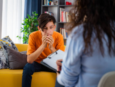 Female psychologist counseling teenage boy in office